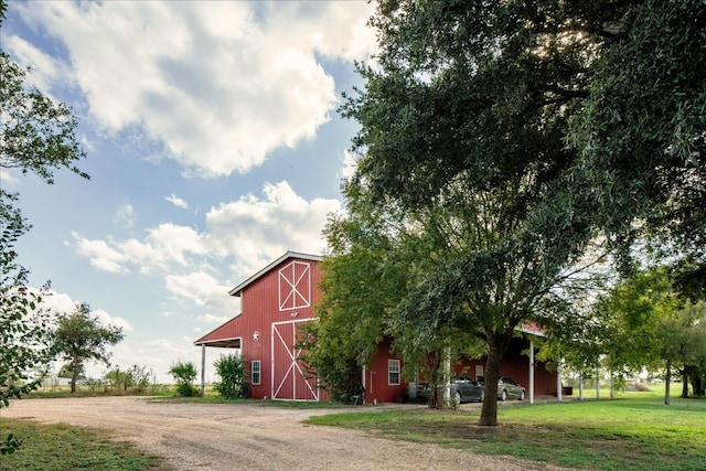 view of property hidden behind natural elements with an outdoor structure and a front yard