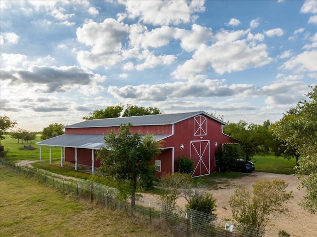 view of outdoor structure featuring a lawn and a rural view