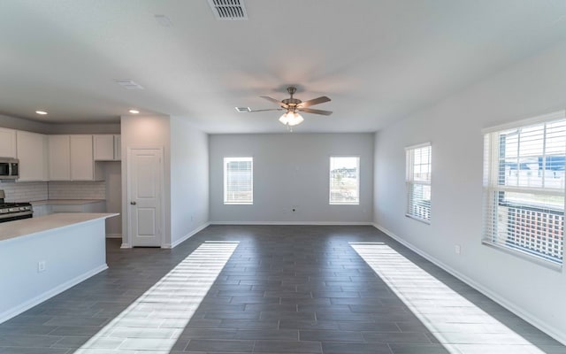 kitchen with appliances with stainless steel finishes, a healthy amount of sunlight, tasteful backsplash, and ceiling fan