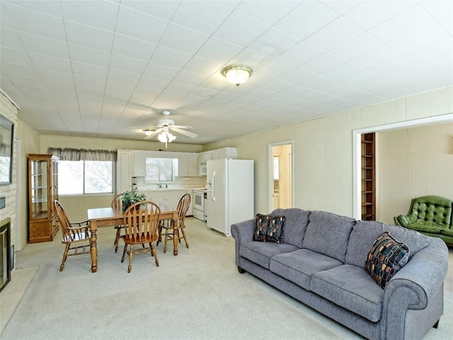 living room with light colored carpet, ceiling fan, and sink