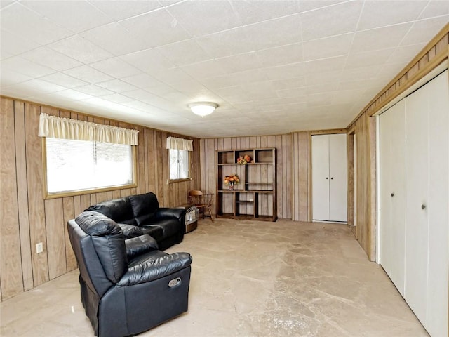 living room featuring concrete floors and wood walls