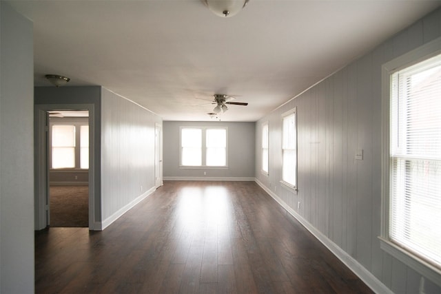 unfurnished room with ceiling fan and dark wood-type flooring