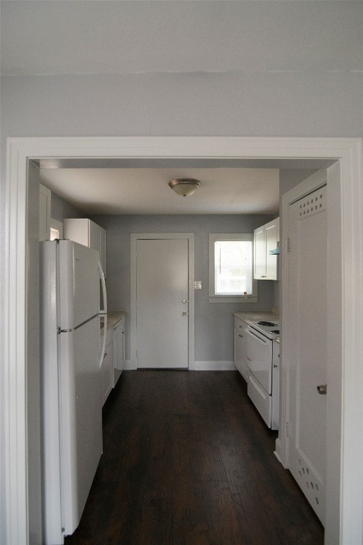 kitchen featuring dark hardwood / wood-style floors, white appliances, and white cabinets