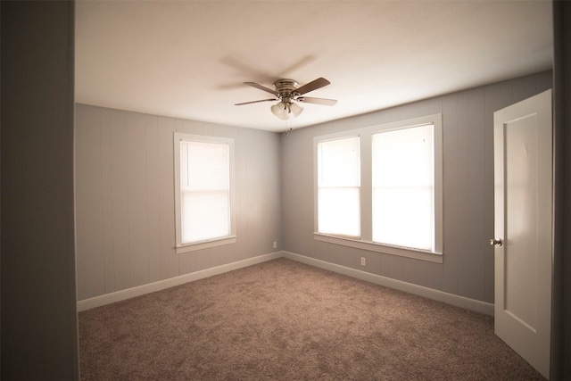 carpeted spare room featuring ceiling fan