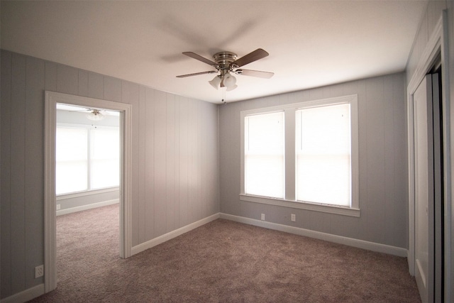 carpeted empty room featuring ceiling fan