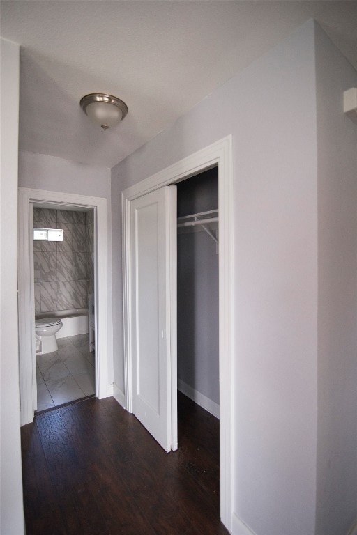 unfurnished bedroom with a closet and dark wood-type flooring