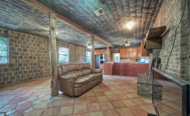 living room featuring brick wall and light tile flooring