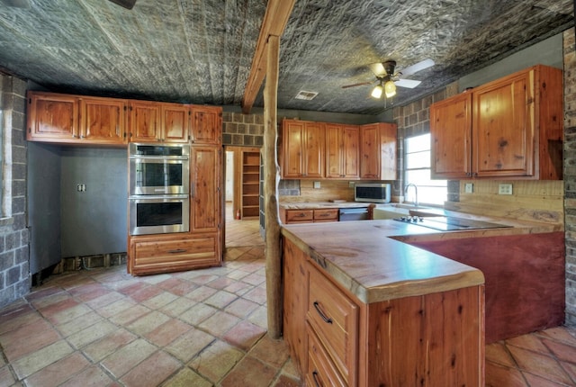 kitchen featuring light tile floors, appliances with stainless steel finishes, ceiling fan, and sink