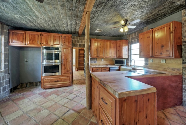 1332 Fm 969, Bastrop, TX 78602 - kitchen with appliances with stainless steel finishes, ceiling fan, and brown cabinets