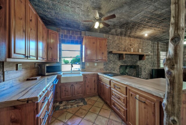 1332 Fm 969, Bastrop, TX 78602 - kitchen with stainless steel microwave, ceiling fan, light countertops, brown cabinets, and black electric stovetop