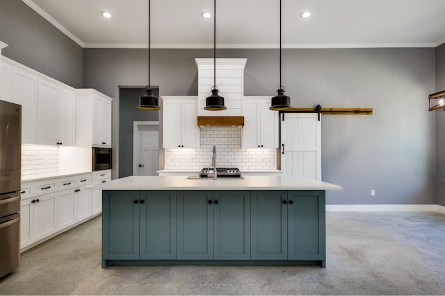 kitchen featuring tasteful backsplash, an island with sink, and decorative light fixtures