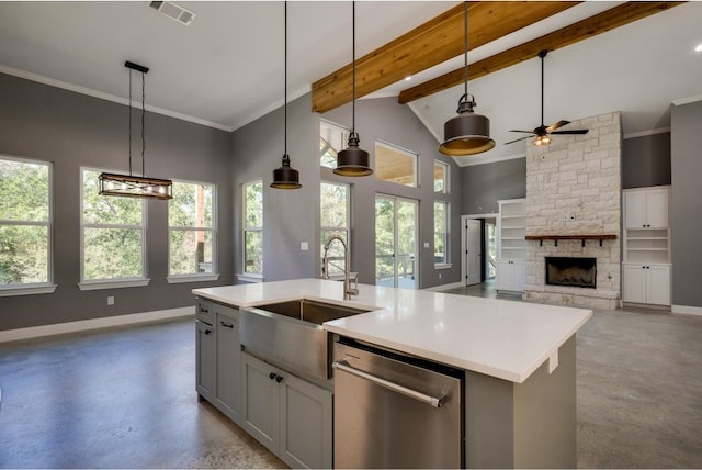 kitchen featuring plenty of natural light, beamed ceiling, an island with sink, and dishwasher