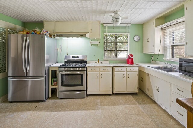 kitchen featuring ceiling fan, appliances with stainless steel finishes, sink, and cream cabinetry