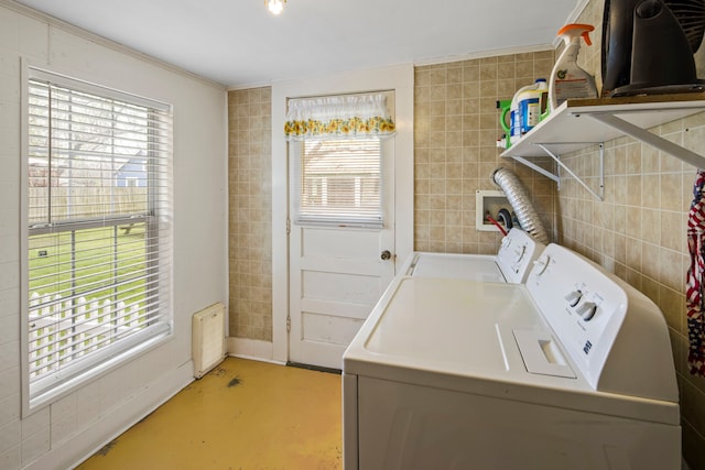 laundry room featuring independent washer and dryer and tile walls