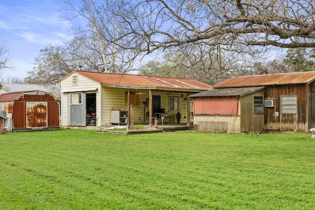 back of house with a lawn and a storage unit