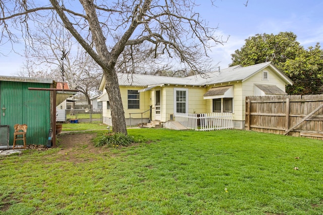 rear view of property featuring a lawn