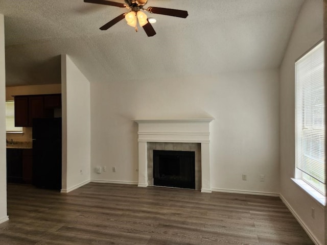 unfurnished living room with a fireplace, hardwood / wood-style flooring, vaulted ceiling, and ceiling fan