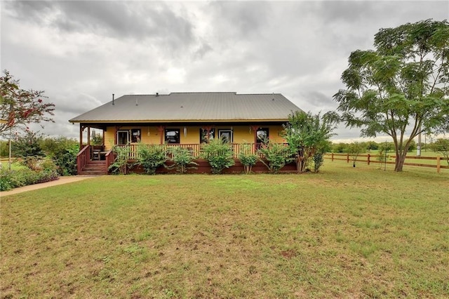 rear view of property featuring a yard and a porch