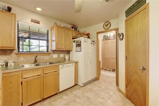 kitchen with sink, tasteful backsplash, white appliances, and light tile floors