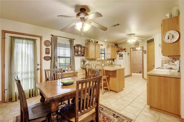 dining room with ceiling fan and light tile floors