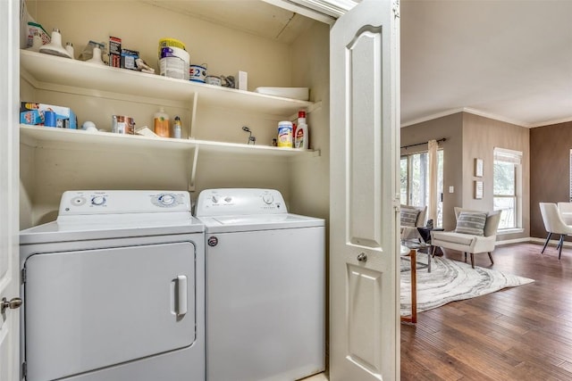 laundry area featuring dark hardwood / wood-style flooring, ornamental molding, and washing machine and clothes dryer