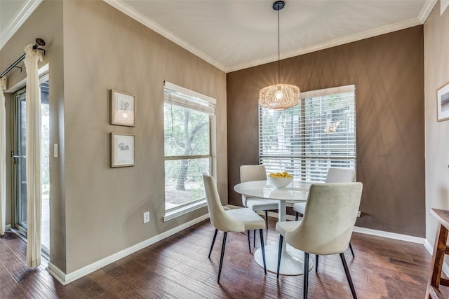 dining space featuring dark hardwood / wood-style floors, crown molding, and a notable chandelier