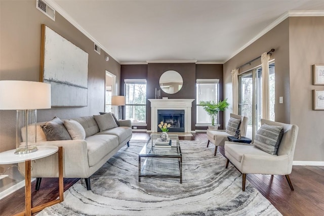 living room featuring crown molding, a healthy amount of sunlight, and wood-type flooring