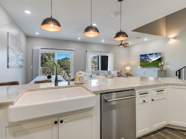 kitchen with light stone counters, sink, decorative light fixtures, and dark hardwood / wood-style flooring