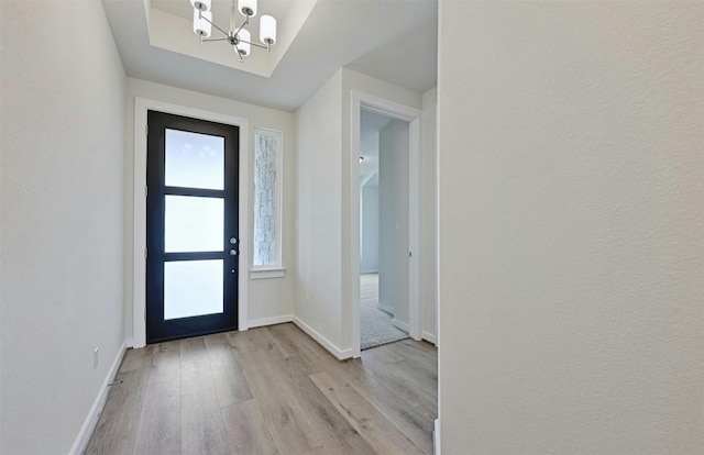 foyer with a notable chandelier, light hardwood / wood-style floors, and a wealth of natural light