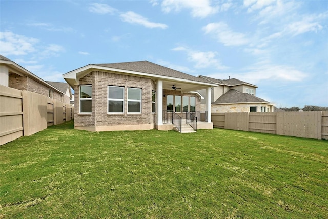 back of property featuring a yard and ceiling fan