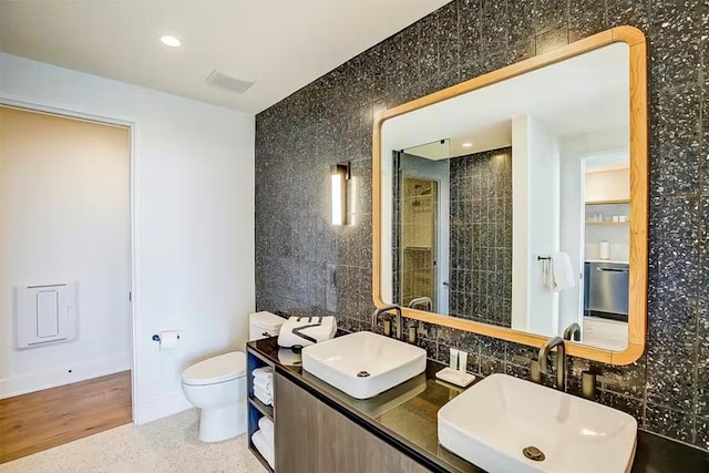 bathroom with tile walls, toilet, and oversized vanity