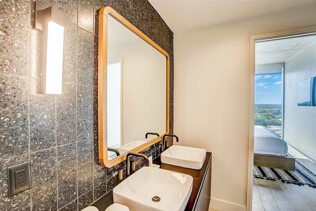 bathroom with tile walls, vanity, hardwood / wood-style floors, and plenty of natural light