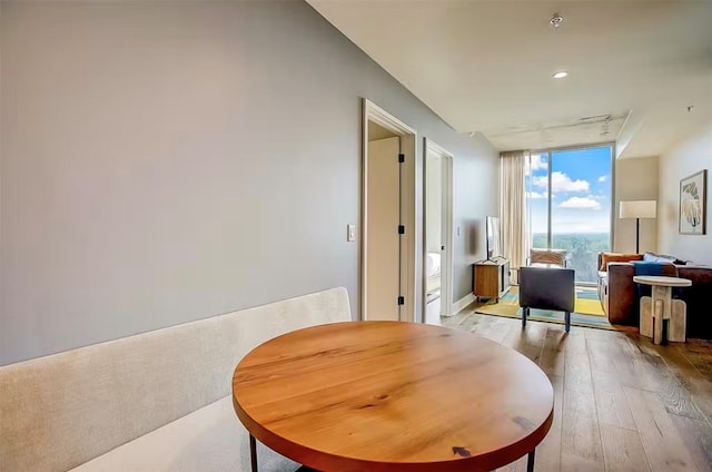 dining space with floor to ceiling windows and light wood-type flooring