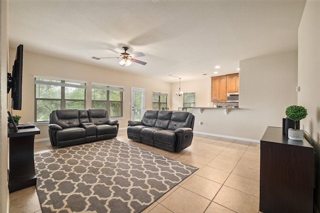 tiled living room featuring ceiling fan and a textured ceiling