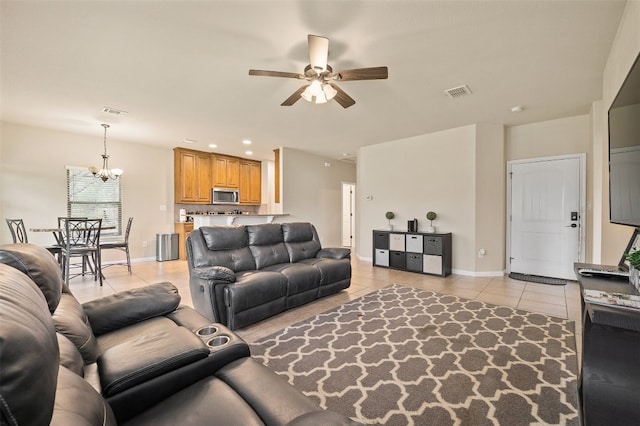 tiled living room featuring ceiling fan with notable chandelier