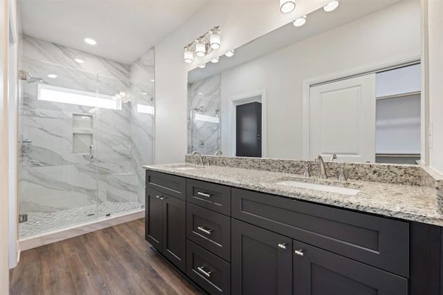 bathroom with double sink vanity, hardwood / wood-style floors, and walk in shower