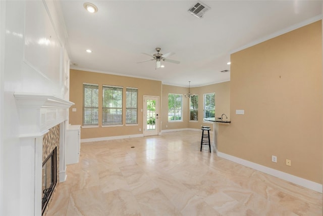 unfurnished living room with ceiling fan, crown molding, and a fireplace