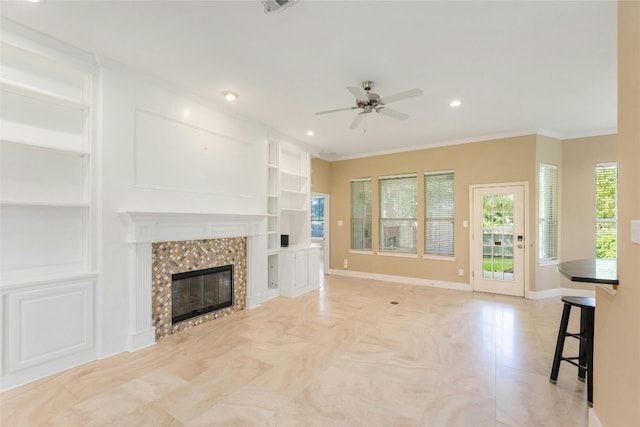 unfurnished living room with ceiling fan, ornamental molding, and a tile fireplace