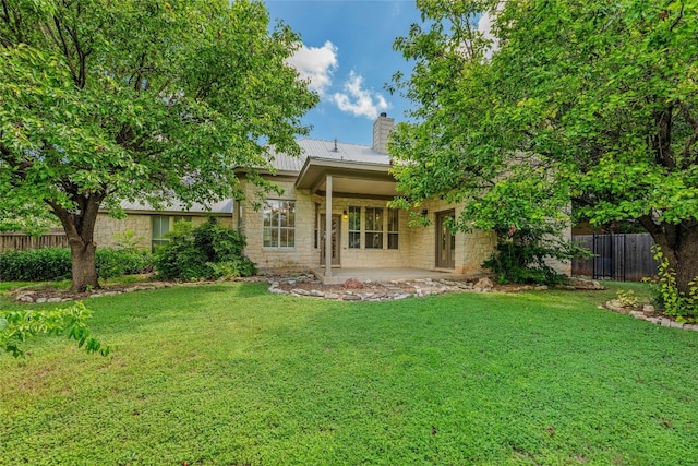 rear view of house featuring a yard and a patio