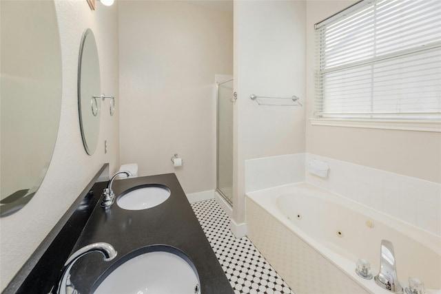 bathroom featuring tile patterned flooring, shower with separate bathtub, and vanity