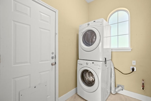 washroom with light tile patterned floors and stacked washing maching and dryer