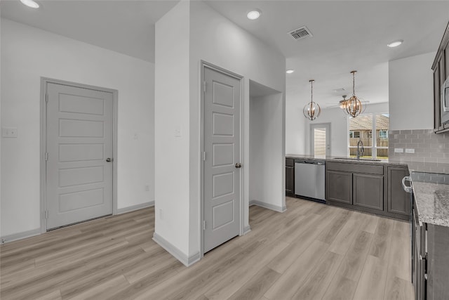 kitchen with an inviting chandelier, stainless steel dishwasher, pendant lighting, light hardwood / wood-style floors, and sink