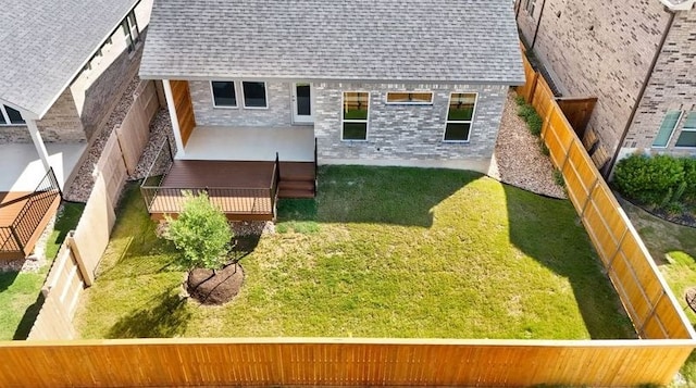 rear view of property with a yard, a fenced backyard, and roof with shingles