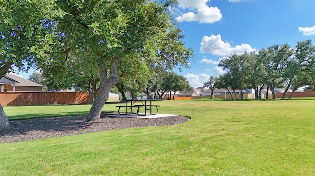 view of home's community with a lawn and fence