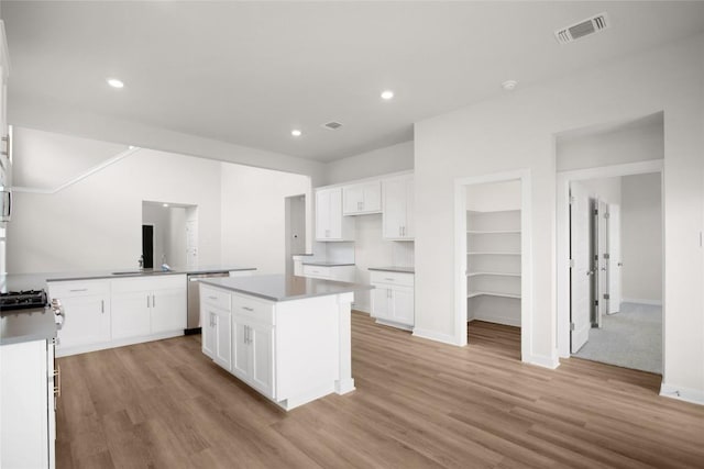 kitchen featuring light wood finished floors, visible vents, white cabinets, and stainless steel dishwasher