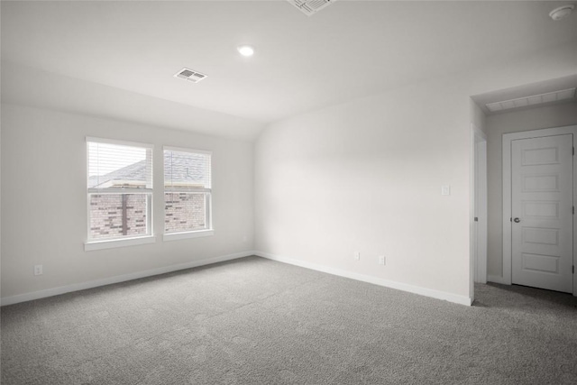 carpeted empty room with visible vents, baseboards, and lofted ceiling