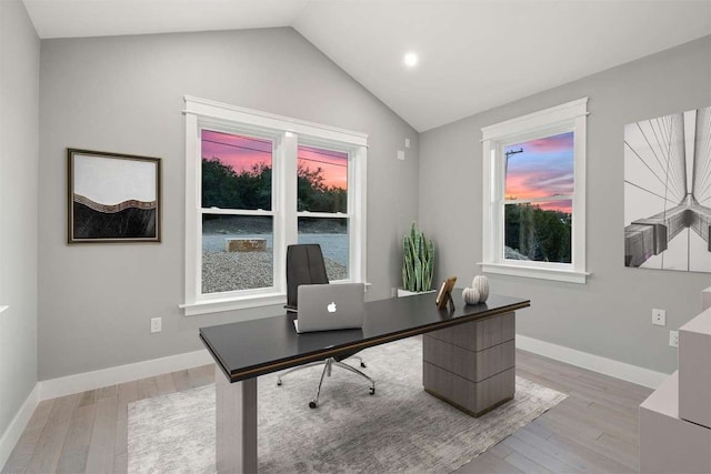 office space with vaulted ceiling and light wood-type flooring