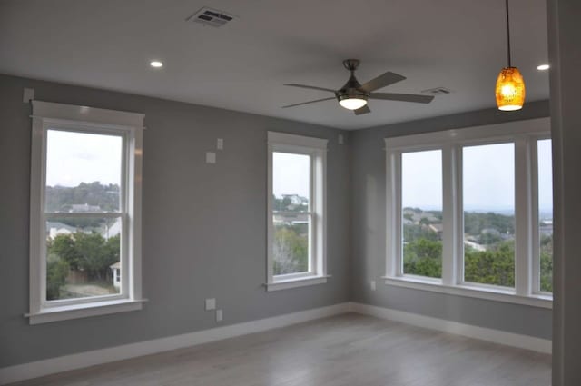 unfurnished room with ceiling fan and light wood-type flooring