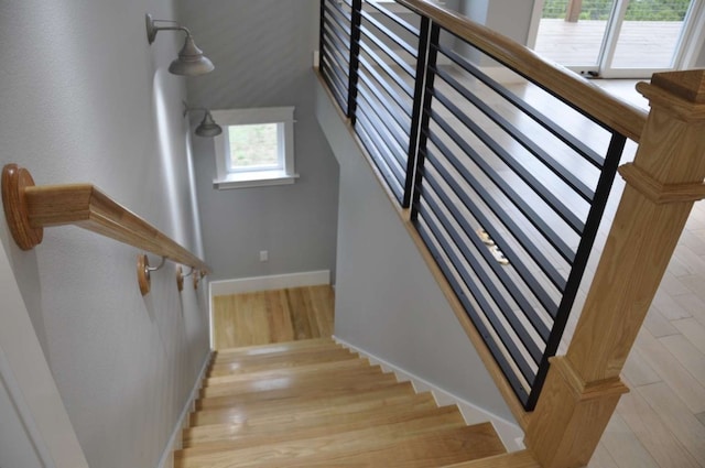 stairs with light wood-type flooring and plenty of natural light