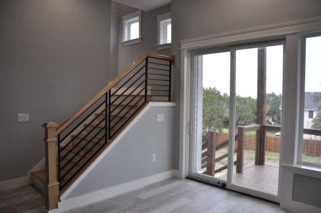 stairway with plenty of natural light and light wood-type flooring